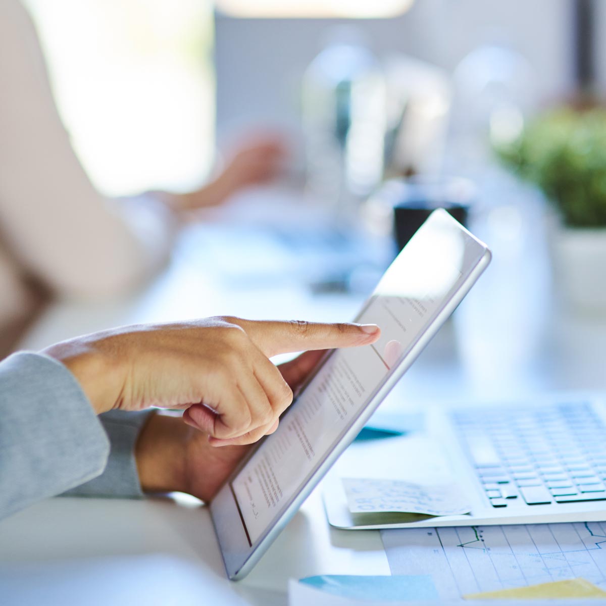 finger pointing at computer tablet