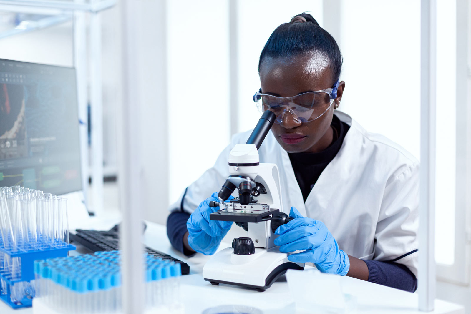 scientist looking through microscope