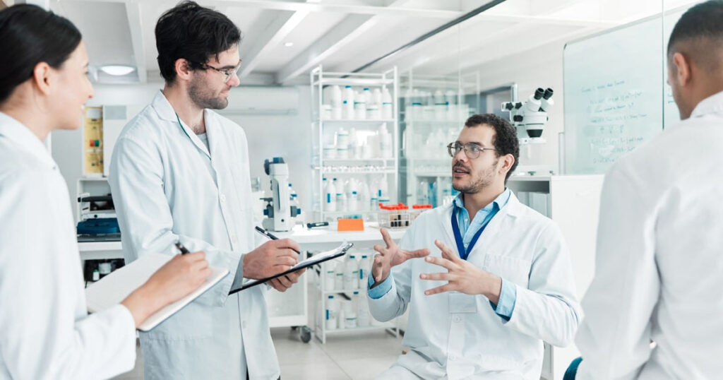 four scientists working together in a lab