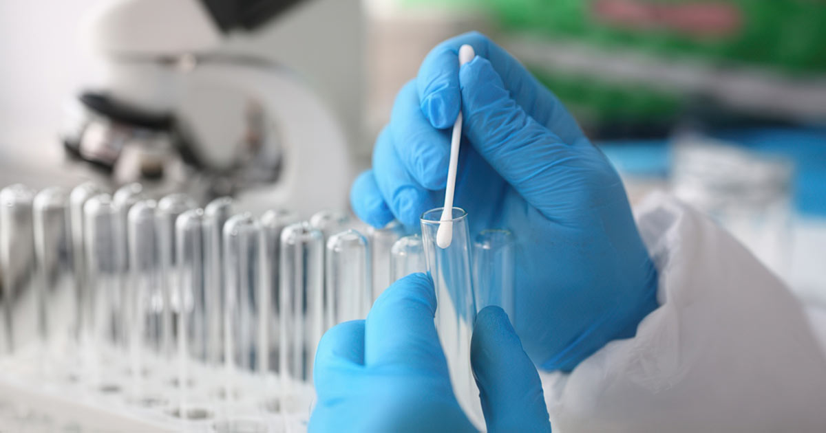 scientist wearing gloves swabbing vial
