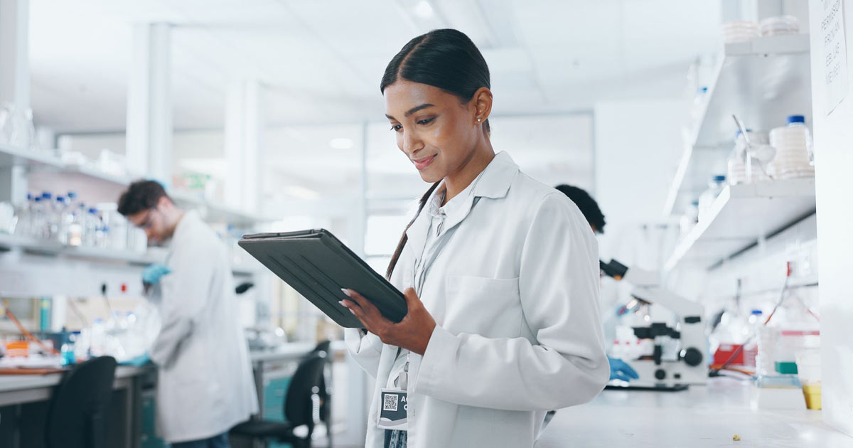 smiling scientist looking at computer tablet