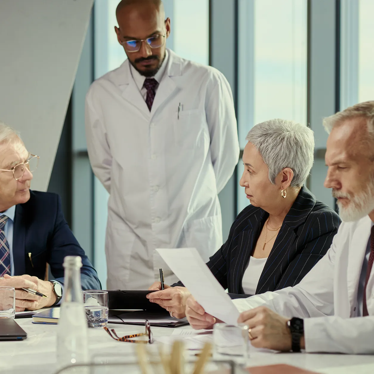 Senior life sciences executives and physicians discuss strategy around a boardroom table.